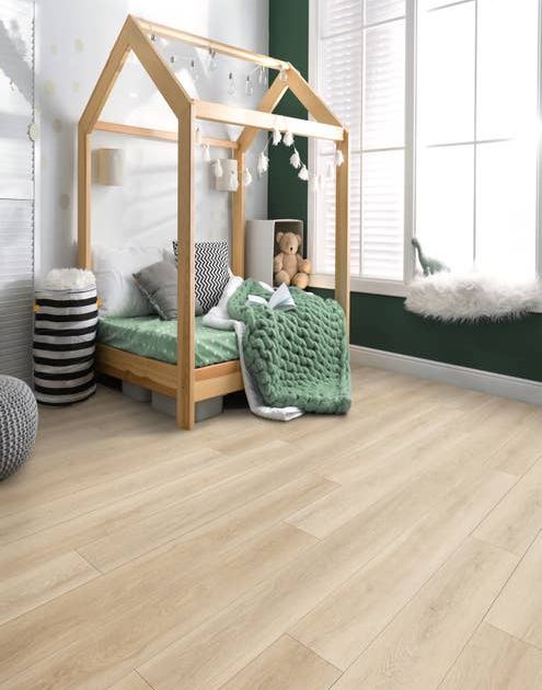 Simple clean child's bedroom with various toys and bedding and a dark green feature wall, a large window, and light wood-look LVP flooring.