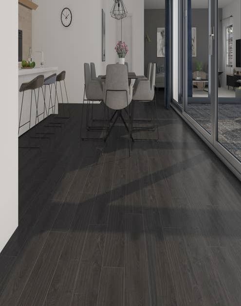 Bold, modern, black woodgrain floor leading to kitchen island, modern dining room table set, and wall of windows