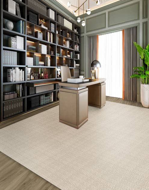 Home study with built-in cabinets and traditional desk sitting atop a tan geometric patterned area rug