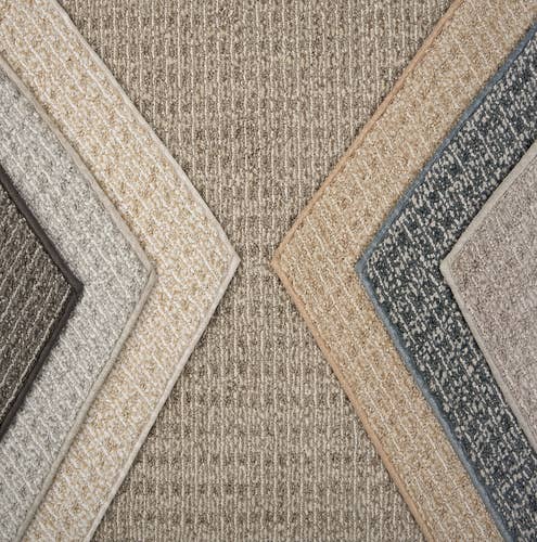 Various beige, gray, and blue distressed berber carpet samples layered on top of each other in a design