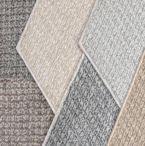 Flat lay of various solid plaid beige, gray, and tan carpet samples