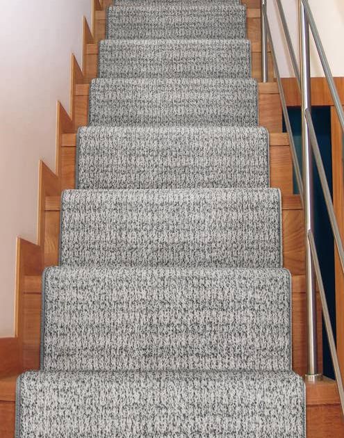 Solid plaid gray carpet runner down warm-toned wood staircase