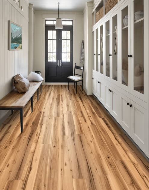 Farmhouse-inspired entry hall with floor-to-ceiling built-in cabinets, wooden bench, chair, and clean rustic woodgrain floor