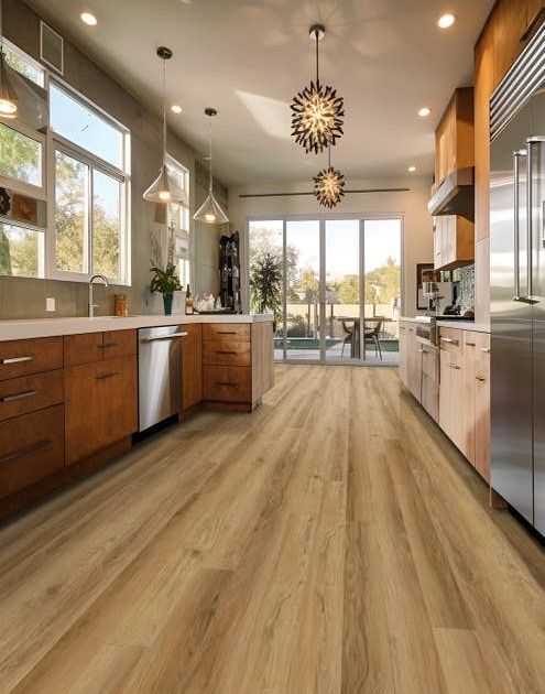 Mid-century modern inspired kitchen with clean, subtle brown woodgrain flooring, textured chandeliers, pendant lights, and sliding glass doors leading to patio