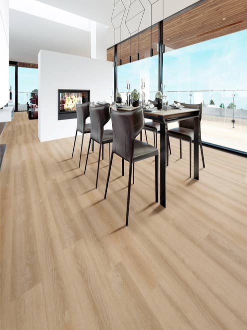 Modern dining area set over light beige, clean floors, with architectural leather chairs, feature fireplace, and bank of large windows