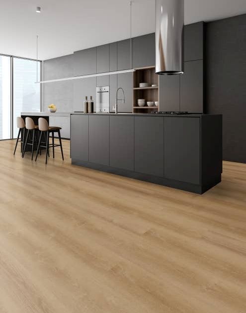 Minimalist industrial kitchen with black cabinets, island, and seating section, with warm golden brown woodgrain floors and floor-to-ceiling windows