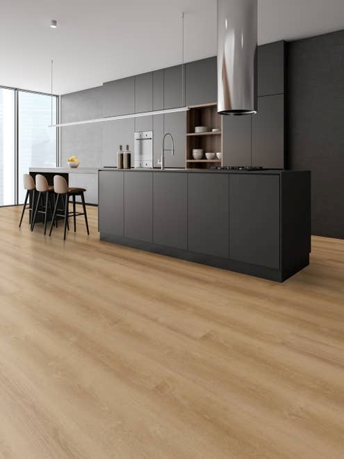 Minimalist industrial kitchen with black cabinets, island, and seating section, with warm golden brown woodgrain floors and floor-to-ceiling windows