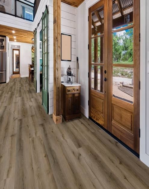 Wooden entry door and hall, with white shiplap walls and lightly-weathered wide plank brown Ash Brown floor