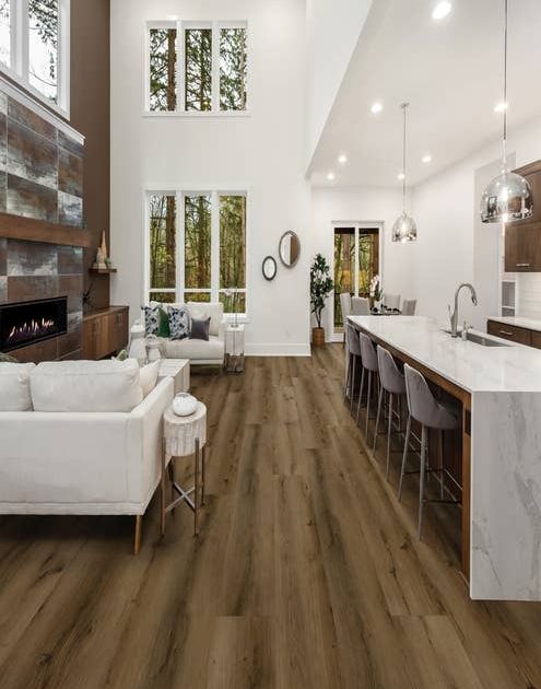Open-concept kitchen and living room, with rustic industrial accents and brown wide-plank weathered floors
