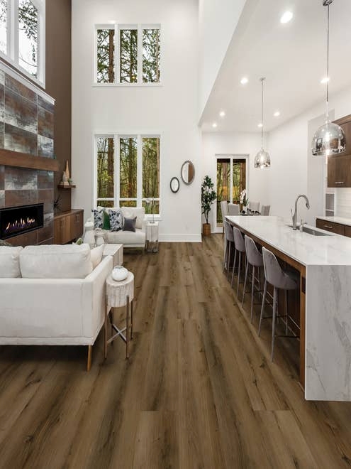 Open-concept kitchen and living room, with rustic industrial accents and brown wide-plank weathered floors