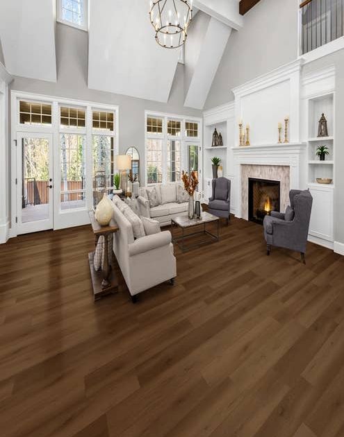 Modern contemporary room with two couches and two armchairs before a fireplace, with built-in shelves, high ceilings, and large windows, with rich tonal Brownstone floor