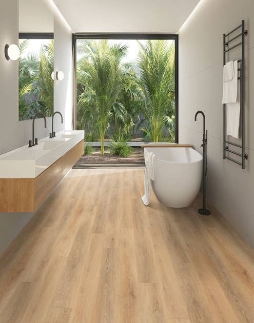 Luxury bathroom with tub and dual-sink hanging wood vanity, with view of massive window filled with fronds