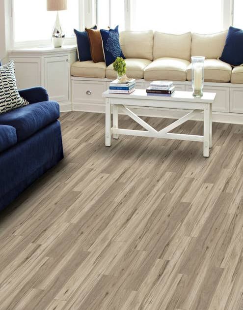 Cream sofa, blue loveseat, and coffee table in bright living room with light gray Timber Land Dockside LVP floor