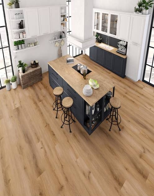 Kitchen with white cabinetry, blue island with tan countertop, bar stools, and large windows in room with light brown wood-look LVP floor