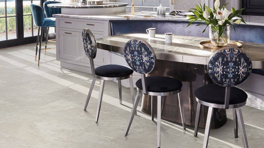 Kitchen with large windows, pendant lights, oversized island, bar stools, and built-in breakfast bench with table and chairs