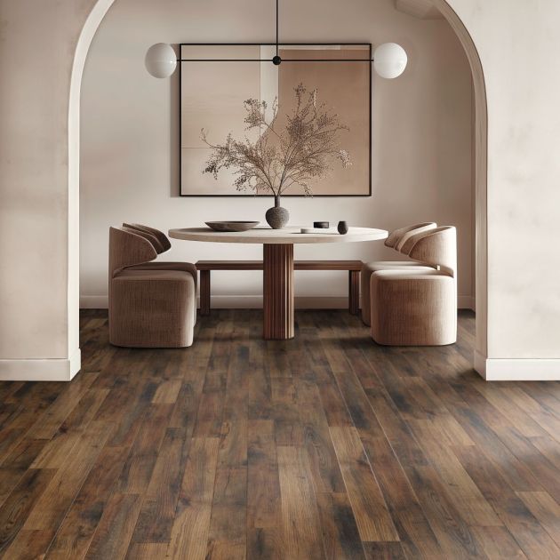 Dining area with arched doorframe, cream walls, brown woodgrain floor, and table and chairs, with large abstract painting in background and modern globe light fixture