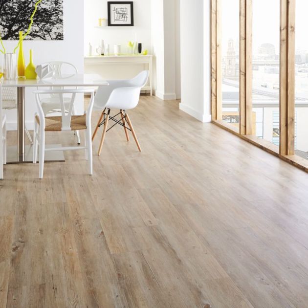 Modern dining area with table, yellow vase, and artwork in bright space with pale oak floor
