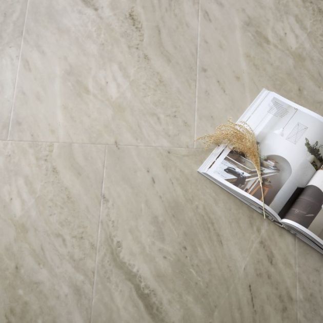 Open magazine and tuft of dried grass over gray marble tile floor
