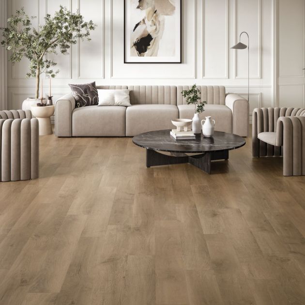 Neutral modern living space with couch, armchairs, and black marble coffee table, set in room with ecru wainscoting and muted brown woodgrain floor