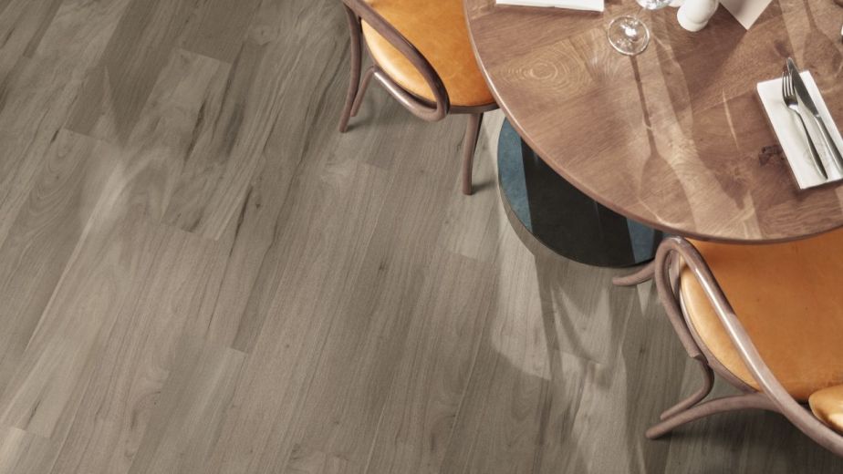 Overhead view of chairs and table with place setting over weathered gray woodgrain floors