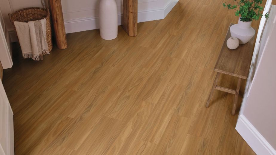 Inviting, organic-toned hallway with golden brown wood flooring, wooden table and bench, and various pieces of pottery