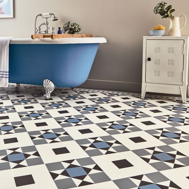 Bathroom with blue bathtub, small cabinet, and blue Heritage Victorian tile