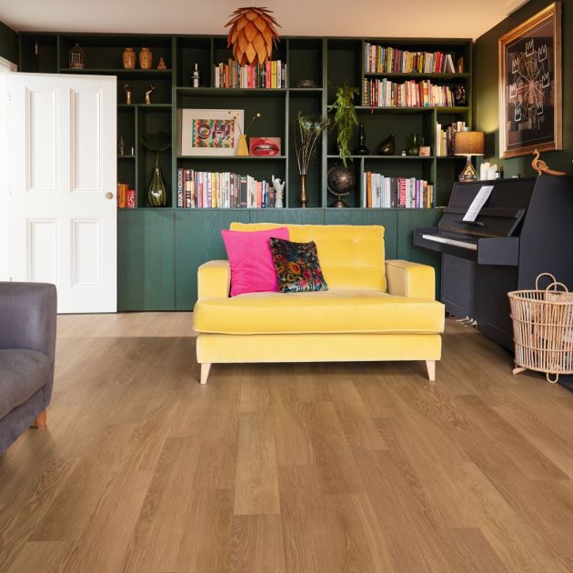 Maximalist living space with yellow loveseat, bookshelves, chandelier, fireplace, and brown woodgrain floor