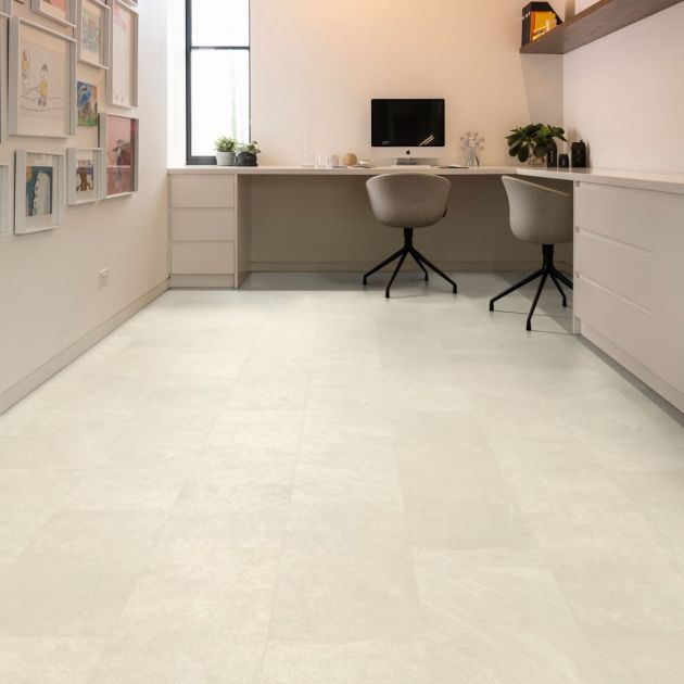 Home office space featuring two rolling chairs at a corner desk with kid's artwork on wall and cream and white tile-look floor