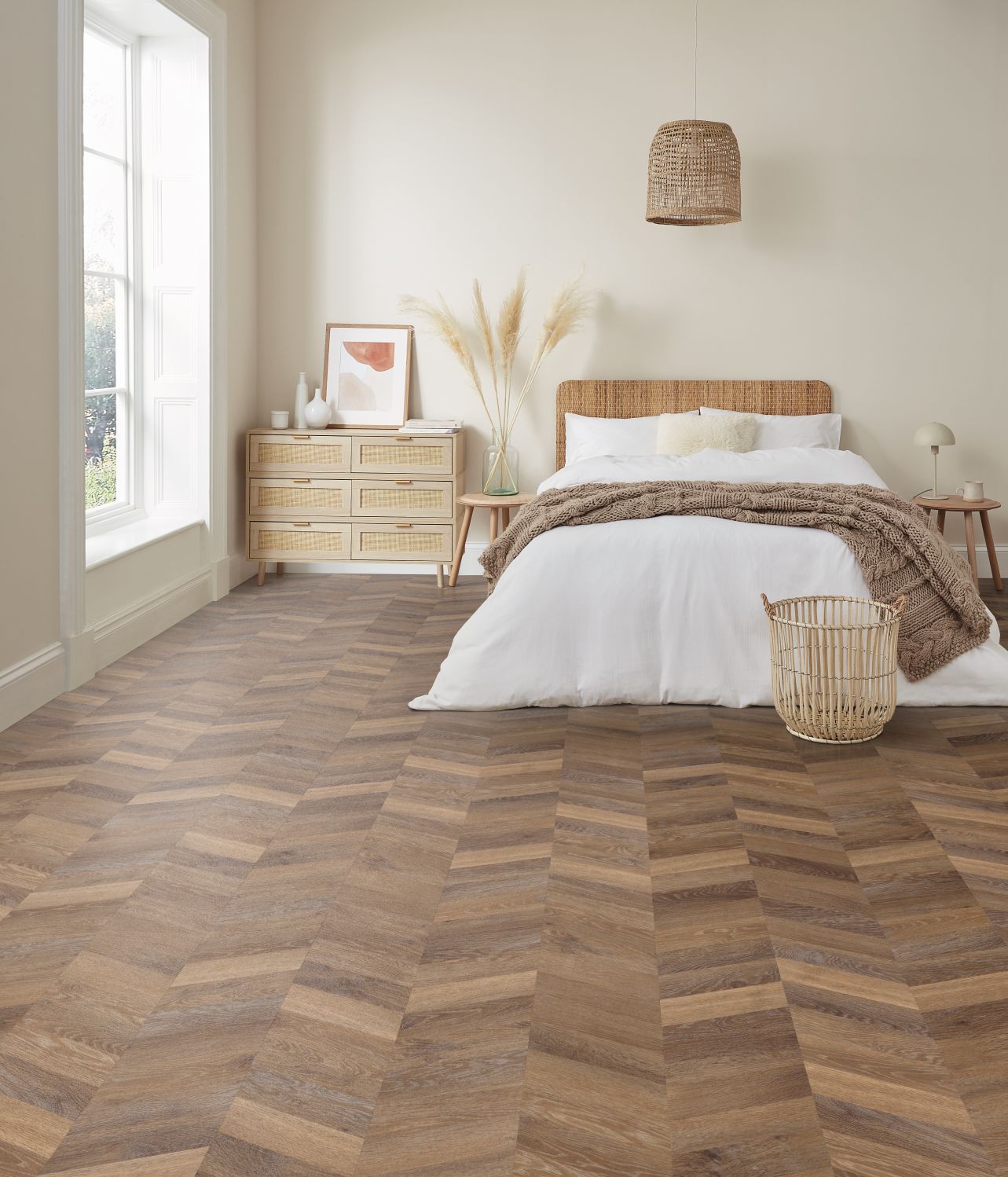 Bedroom with natural light and pale brown chevron woodgrain flooring, with bed, nightstand, and various organic elements