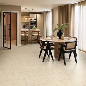 Dining space and kitchenette with large curtained windows, arched door, and cream LVT floor
