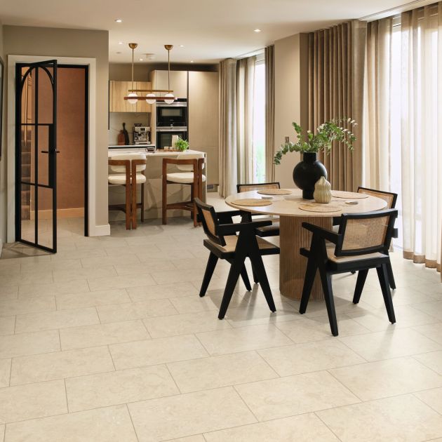 Dining space and kitchenette with large curtained windows, arched door, and cream LVT floor