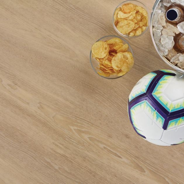 Soccer ball, chip cups, and beverages in ice bucket over taupe and beige woodgrain LVP floor