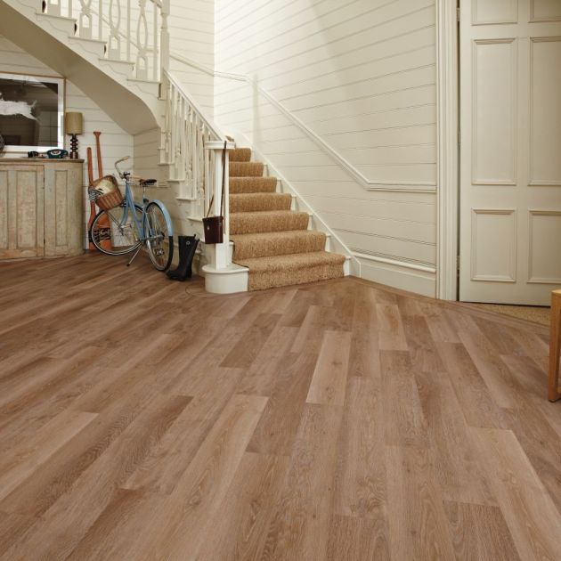 Hallway with shiplap walls, assorted vintage and athletic paraphernalia, and light brown floors installed at a diagonal and with a design border