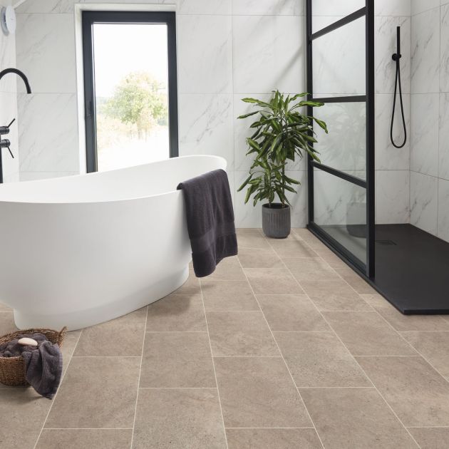 Bright bathroom with free-standing tub, walk-in shower, large window, houseplant, and neutral tile floor