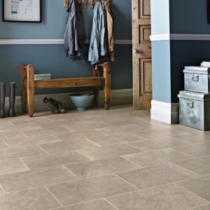 Blue hallway with coat hooks, bench, shoes, and metal trunks over neutral greige tile floor