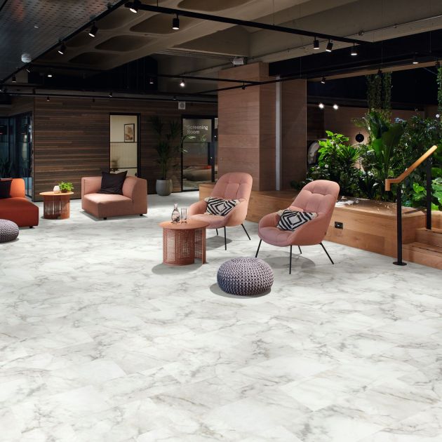 Commercial seating space featuring various chairs and tables, potted plants, track lighting, and marableLVT floors
