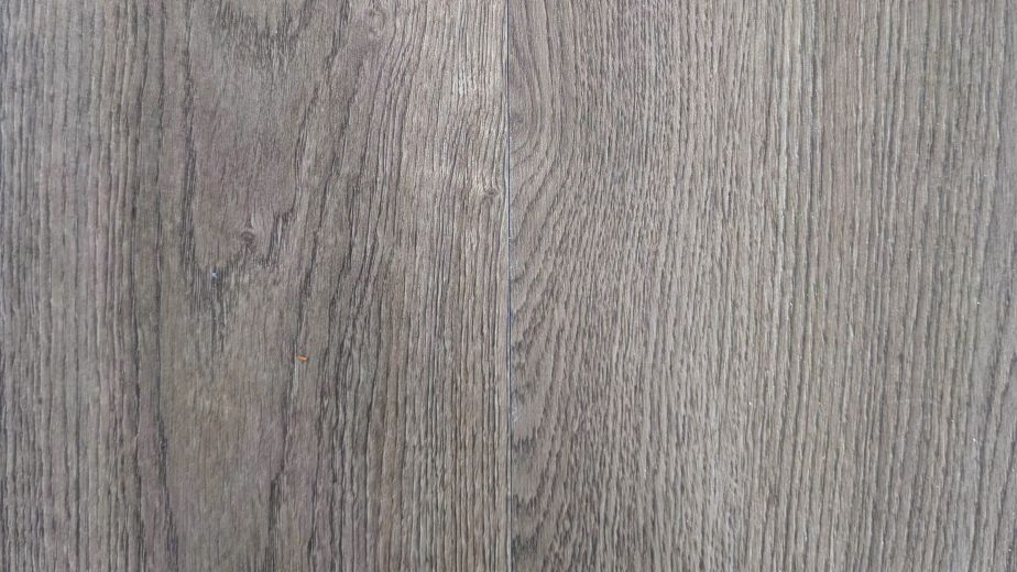 Arbor glue down luxury vinyl plank sample showing woodgrain design, brown tones, and subtle warm undertones