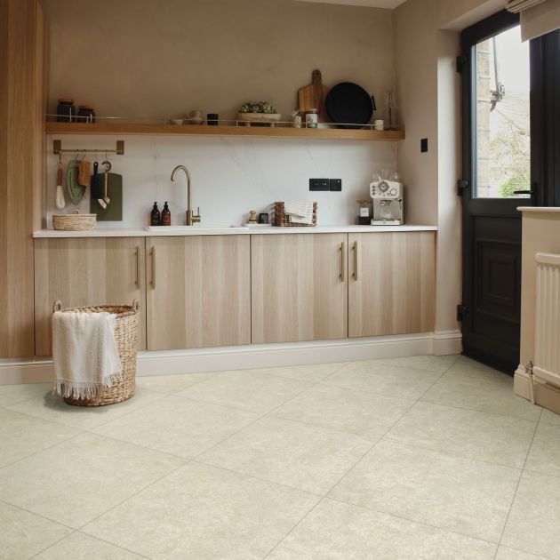Utility space with beige cabinetry, sink, shelving, black back door, and cream tile floor