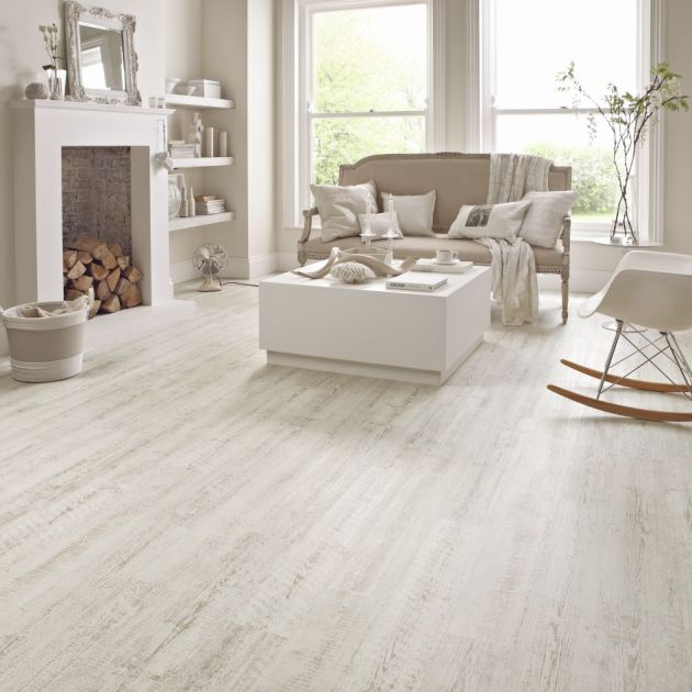 Cottage-feel living space with loveseat, coffee table, and rocking chair in various shades of cream and gray, in room with distressed white woodgrain floor